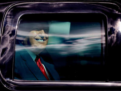 Outgoing President Trump waves to supporters lined along on the route to his Mar-a-Lago estate on January 20, 2021, in West Palm Beach, Florida.