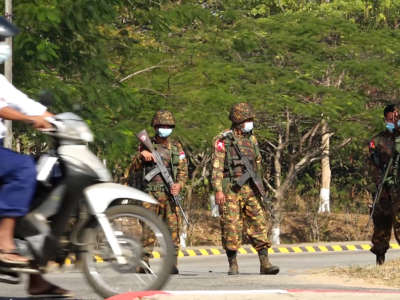 Soldiers stand guard on a street in Naypyidaw on February 1, 2021, after the military detained the country's de facto leader Aung San Suu Kyi in a coup.