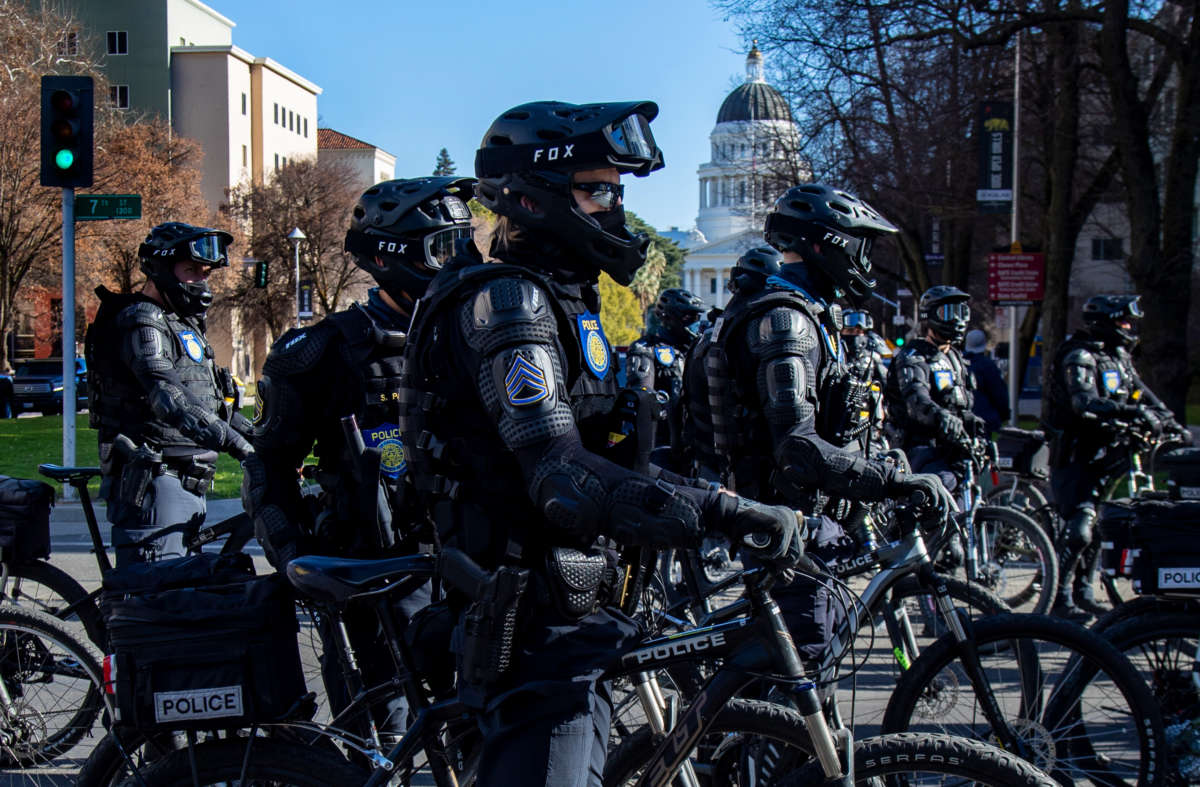 Sacramento Police officers in riot gear on bikes stay close to Antifa protesters marching near the California State Capitol on January 20, 2021, in Sacramento, California.