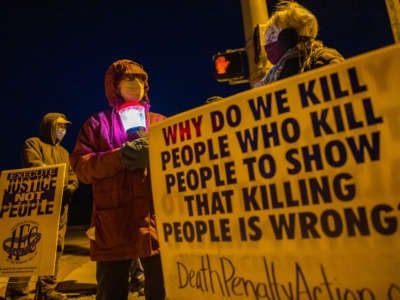 Bloomington anti-death-penalty activist Glenda Breeden holds a lamp while protesting against the execution of Lisa Montgomery and two others, in Bloomington, Indiana, on January 12, 2021.