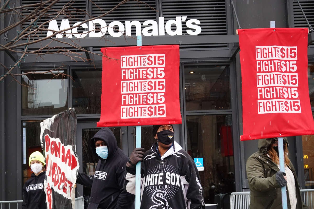 Protestors hold signs saying "Fight for $15" in front of McDonald's corporate headquarters.