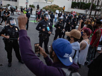 Black Lives Matters protesters stand united as they confront LAPD, protesting the killing of George Floyd in Minnesota by police on May 27, 2020, in Los Angeles, California.