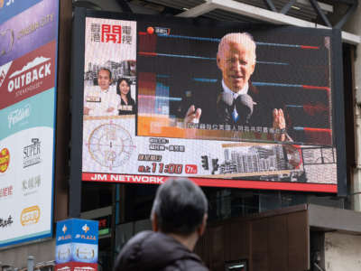 A man is seen watching the news report of the inauguration of U.S. President Joe Biden on a large screen in Hong Kong, China. on January 21, 2021.