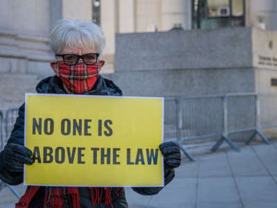 A participant holding a “No One Is Above The Law” sign at a protest on the first day of Donald Trump's impeachment trial. Members of the New York City activist group Rise and Resist held a demonstration outside the Thurgood Marshall United States Courthouse in Manhattan.