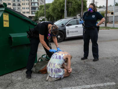 Medics with Austin-Travis County EMS check a woman with potential COVID-19 symptoms after she was found unconscious in a parking lot on August 3, 2020, in Austin, Texas. Austin's especially high unsheltered population is considered vulnerable to the pandemic.