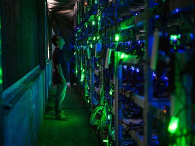A bitcoin mine site manager checks mining equipment inside a bitcoin mine near Kongyuxiang, Sichuan, China.