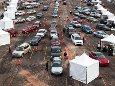 People drive their cars to medical tents at a mass COVID-19 vaccination event on January 30, 2021, in Denver, Colorado.