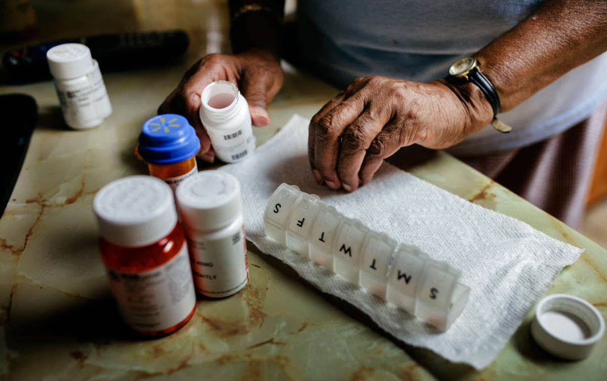 A person sorts medications, pharmaceuticals