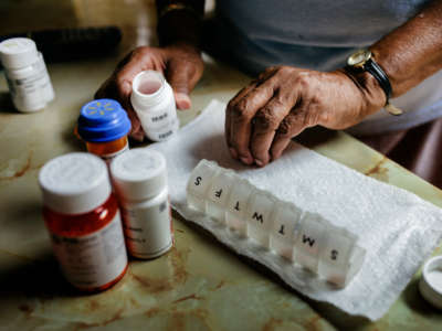 A person sorts medications, pharmaceuticals