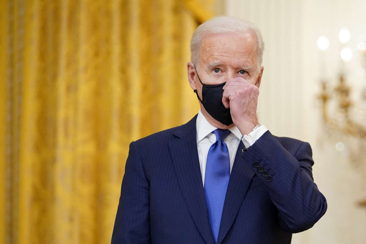 Joseph Robinette Biden adjusts his mask