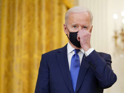 Joseph Robinette Biden adjusts his mask