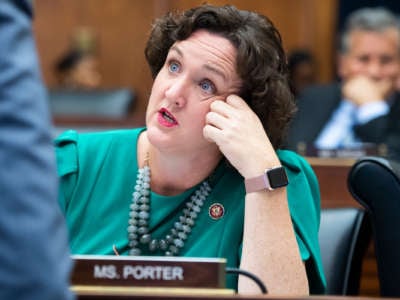 Katie Porter talks to someone at her desk