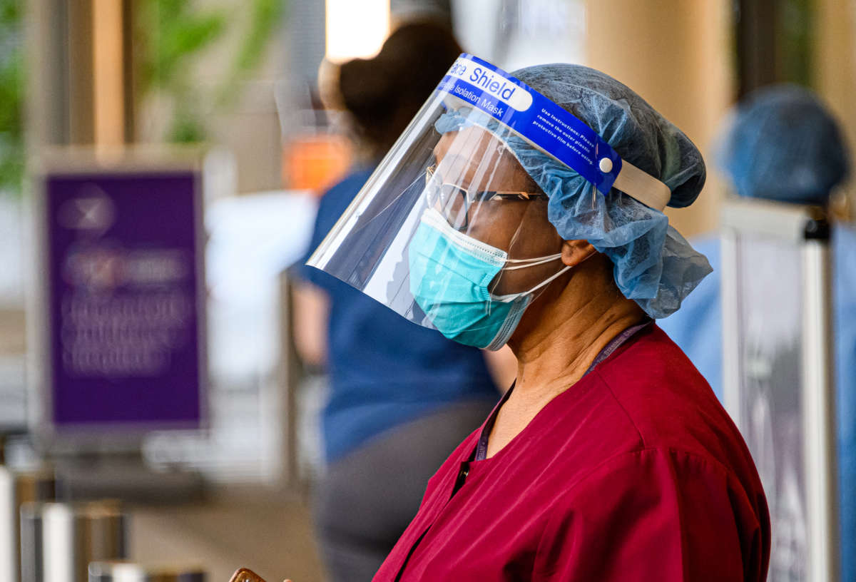 A medical worker looks onward, wearily