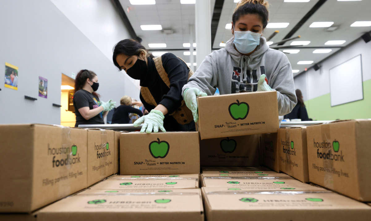Volunteers stack emergency distribution boxes on a pallet at the Houston Food Bank on February 20, 2021, in Houston, Texas.