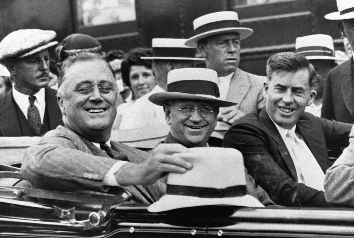President Franklin D. Roosevelt (left) rides in an automobile with Secretary of the Interior Harold L. Ickes (center), and Secretary of Agriculture Henry A. Wallace (right). The photo was taken in August of 1933, at the beginning of the New Deal administration.