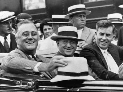 President Franklin D. Roosevelt (left) rides in an automobile with Secretary of the Interior Harold L. Ickes (center), and Secretary of Agriculture Henry A. Wallace (right). The photo was taken in August of 1933, at the beginning of the New Deal administration.