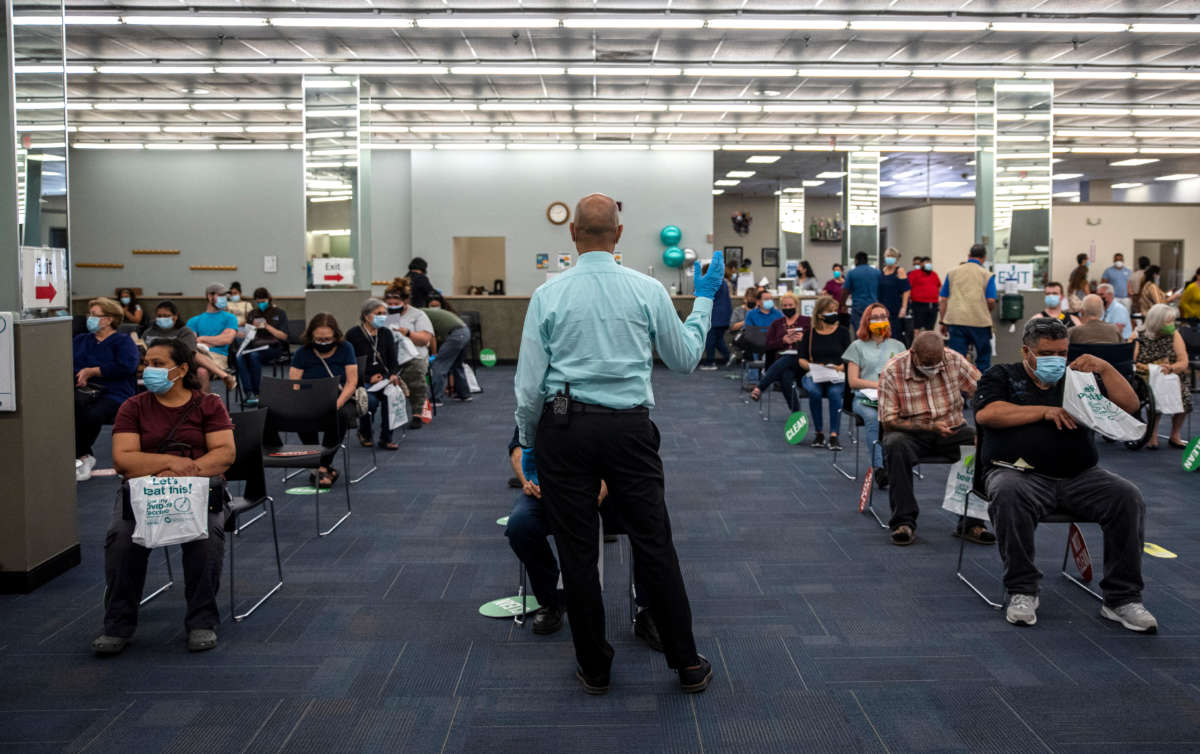 A worker calls out a time for some patients to be able to leave after being vaccinated at a vaccination site at a senior center on March 29, 2021, in San Antonio, Texas.