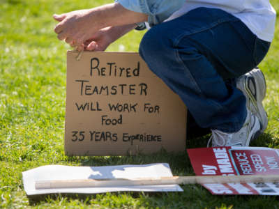 Jan Kacher of Deerfield, Michigan, adjusts a sign as he rallies on the West Front of the U.S. Capitol building with fellow Teamsters Union retirees who traveled from across the country to voice their opposition to deep cuts to their pension benefits on April 14, 2016, in Washington, D.C.