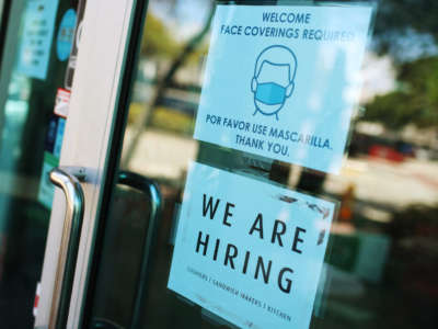 A "we are hiring" sign is seen in front of a store on March 5, 2021, in Miami, Florida.