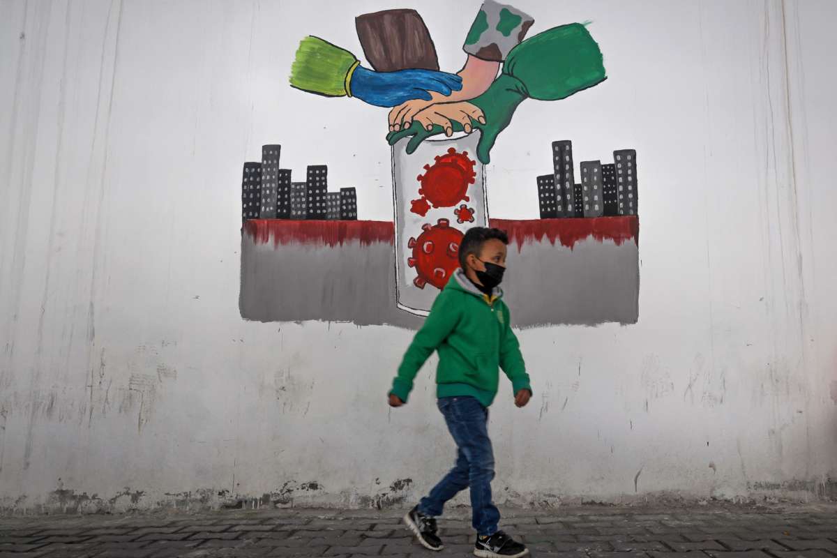 A little boy walks past a mural