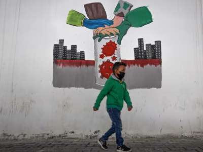 A little boy walks past a mural