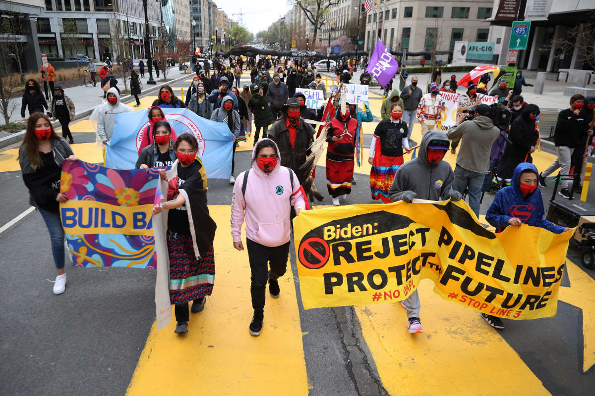 Indigenous environmental activists march through Black Lives Matter Plaza on their way to the White House as part of a protest against oil pipelines on April 1, 2021, in Washington, D.C.