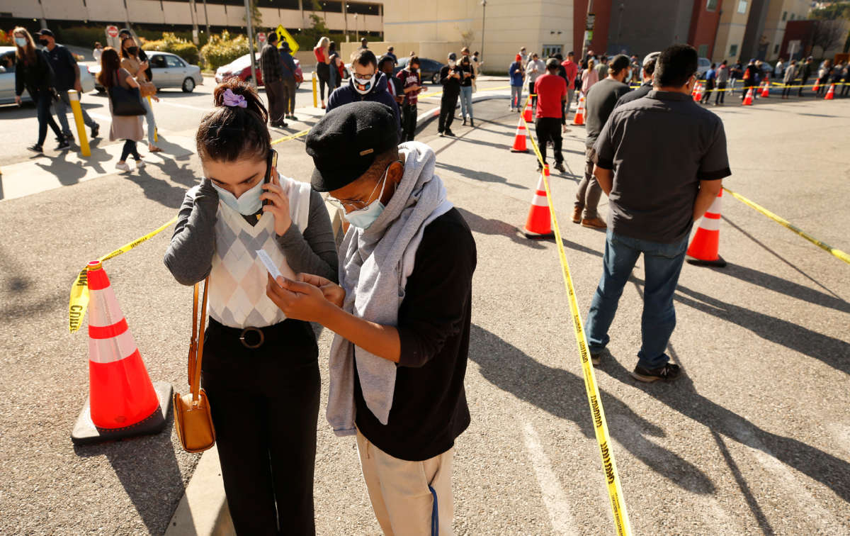 People wait in line at the opening of the Cal State L.A. walk-up mass vaccine site which is administering the Johnson & Johnson one dose shot on April 8, 2021, in Los Angeles, California.