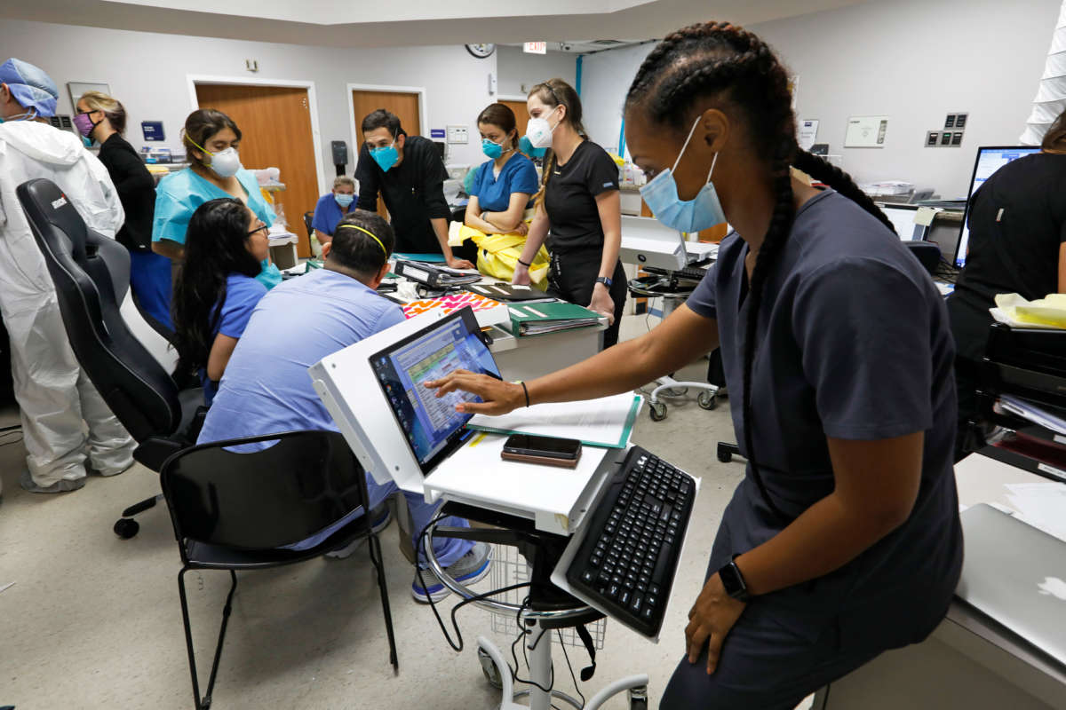 Medical students and staff members on the COVID-19 ward at United Memorial Medical Center gather to go over patients' status at the start of their shift on July 1, 2020.