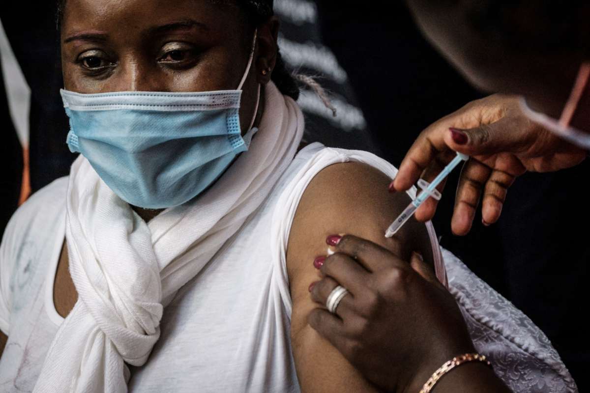 A masked woman is administered the vaccine