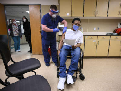 Kelly Markham, an RN supervisor at Faribault Prison, administers the state's first COVID-19 vaccination to a medically vulnerable incarcerated person, Edward Anderson, on January 4, 2021 in Faribault, Minnesota.