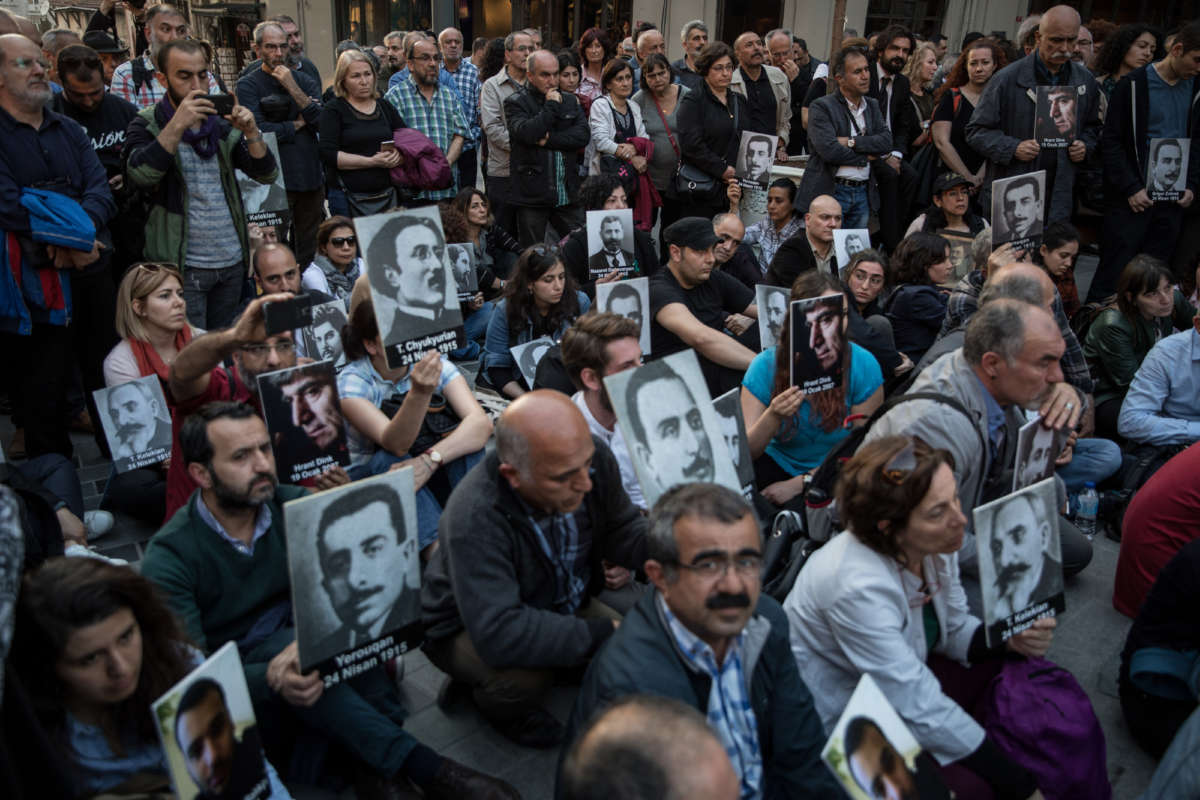 People hold pictures of victims during a memorial to commemorate the 1915 Armenian mass killings on April 24, 2018, in Istanbul, Turkey.