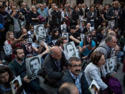 People hold pictures of victims during a memorial to commemorate the 1915 Armenian mass killings on April 24, 2018, in Istanbul, Turkey.