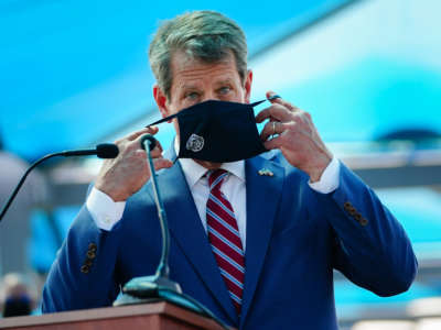 Georgia Gov. Brian Kemp puts on a mask after speaking at a press conference on August 10, 2020, in Atlanta, Georgia.