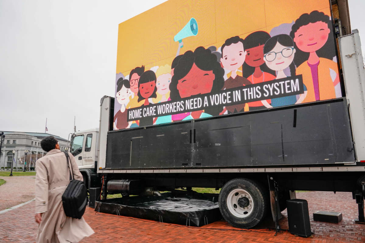 A person walks past an LED display during a protest calling on Congress to invest in care jobs at Union Station on March 25, 2021, in Washington, D.C.