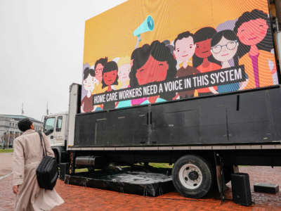 A person walks past an LED display during a protest calling on Congress to invest in care jobs at Union Station on March 25, 2021, in Washington, D.C.