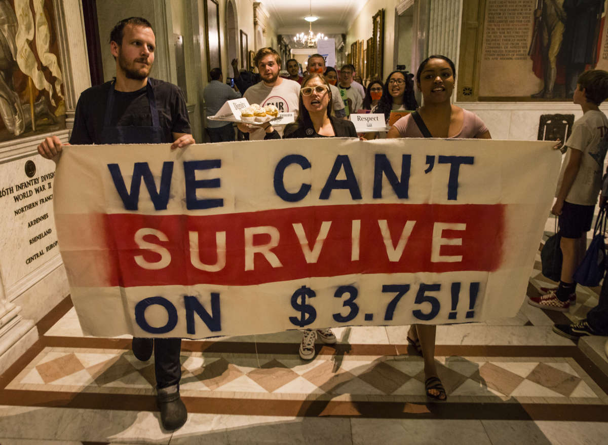 Waiters, waitresses and other hospitality workers that rely on tips for income take part in a rally at the Massachusetts State House in Boston to convince lawmakers to raise the $3.75 minimum wage for restaurant workers on June 12, 2018.