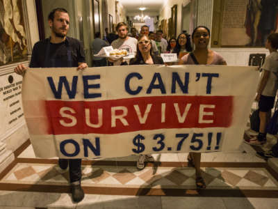 Waiters, waitresses and other hospitality workers that rely on tips for income take part in a rally at the Massachusetts State House in Boston to convince lawmakers to raise the $3.75 minimum wage for restaurant workers on June 12, 2018.