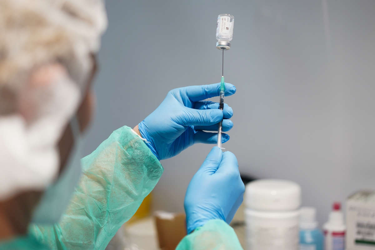 A medical worker draws up a syringe of the vaccine