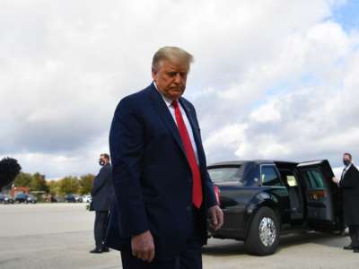 Trump stares at the ground, disappointed and orange