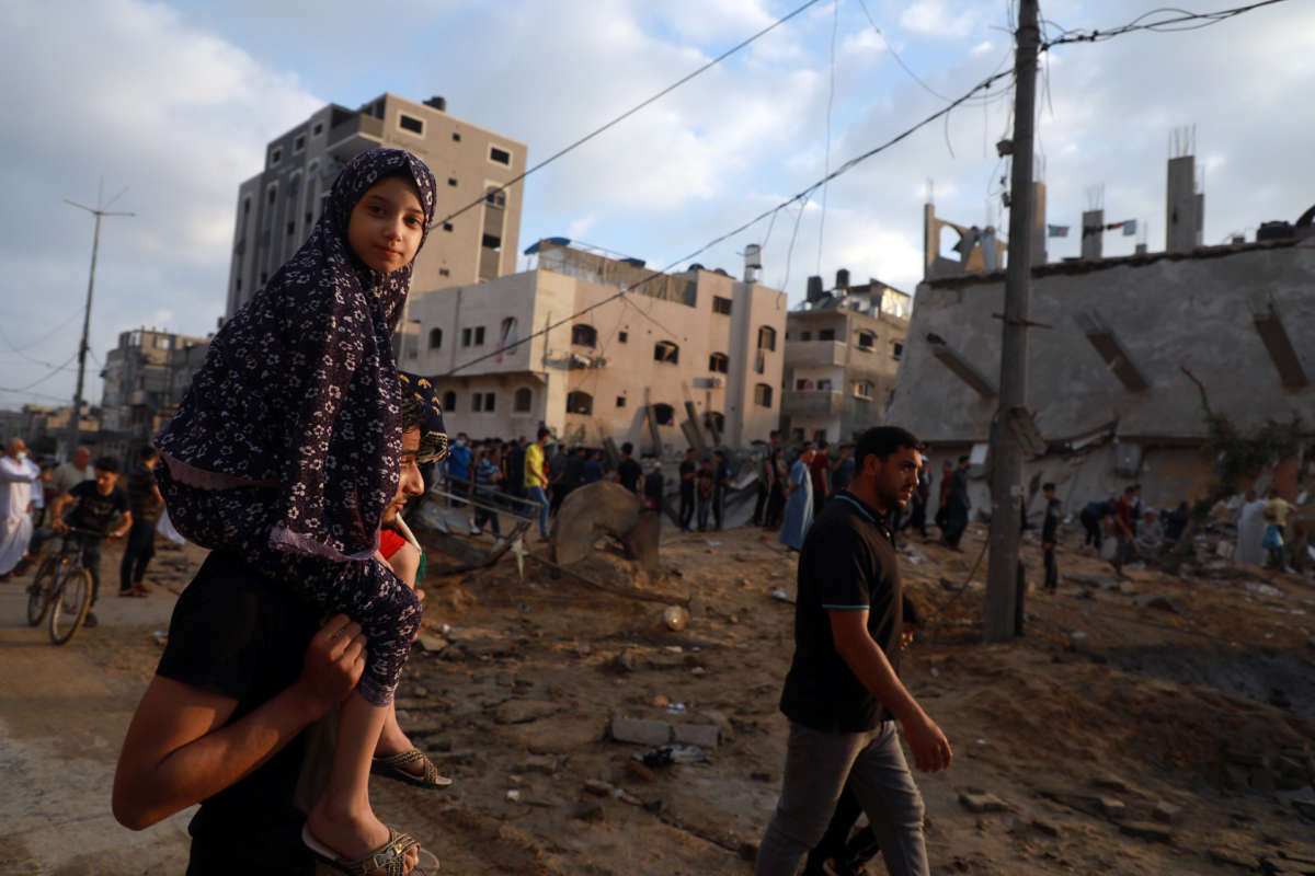 Palestinians gather at the site where buildings and houses were hit in Israeli air strikes in the northern Gaza Strip on May 13, 2021.