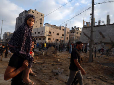Palestinians gather at the site where buildings and houses were hit in Israeli air strikes in the northern Gaza Strip on May 13, 2021.