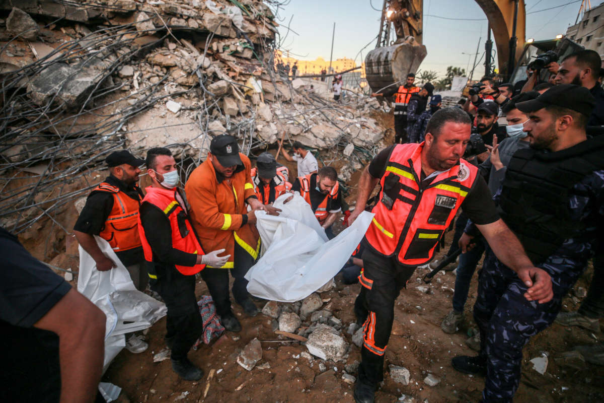 Palestinian civil defense teams take part in rescue works at the rubbles of a building belonging to a Palestinian family after Israeli fighter jets conducted airstrikes in Beit Lahia, Gaza, on May 13, 2021.