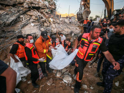 Palestinian civil defense teams take part in rescue works at the rubbles of a building belonging to a Palestinian family after Israeli fighter jets conducted airstrikes in Beit Lahia, Gaza, on May 13, 2021.