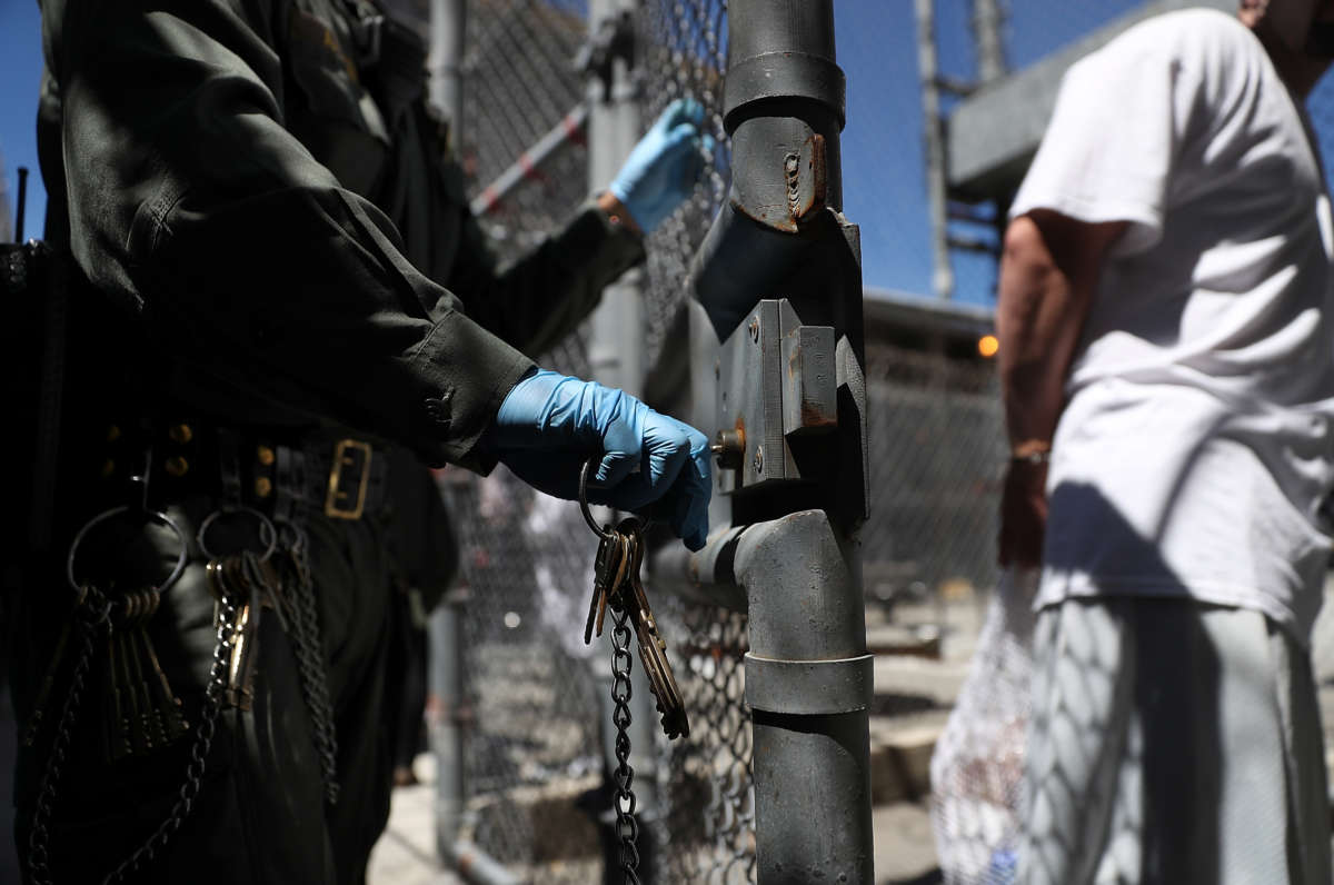 A man is locked into an outdoor prison yard