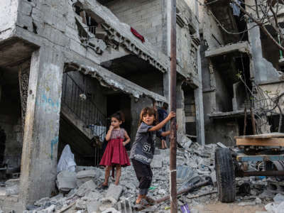 Palestinian children play in front of their destroyed homes in Beit Hanoun following the Israel airstrikes in Gaza on May 26, 2021.