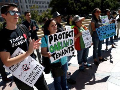 Members of the community attend a rally for tenants rights at Frank Ogawa Plaza in front of City Hall in Oakland, California, on September 26, 2017.