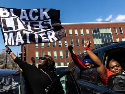 A woman holds a Black Lives Matter flag during the funeral service of Daunte Wright outside the Shiloh Temple International Ministries in Minneapolis, Minnesota, on April 22, 2021.