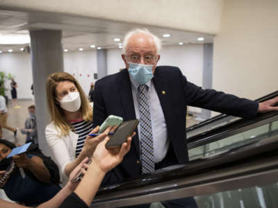 Sen. Bernie Sanders talks with reporters as he makes his way to the Senate floor for a vote in Washington on Wednesday, April 28, 2021.