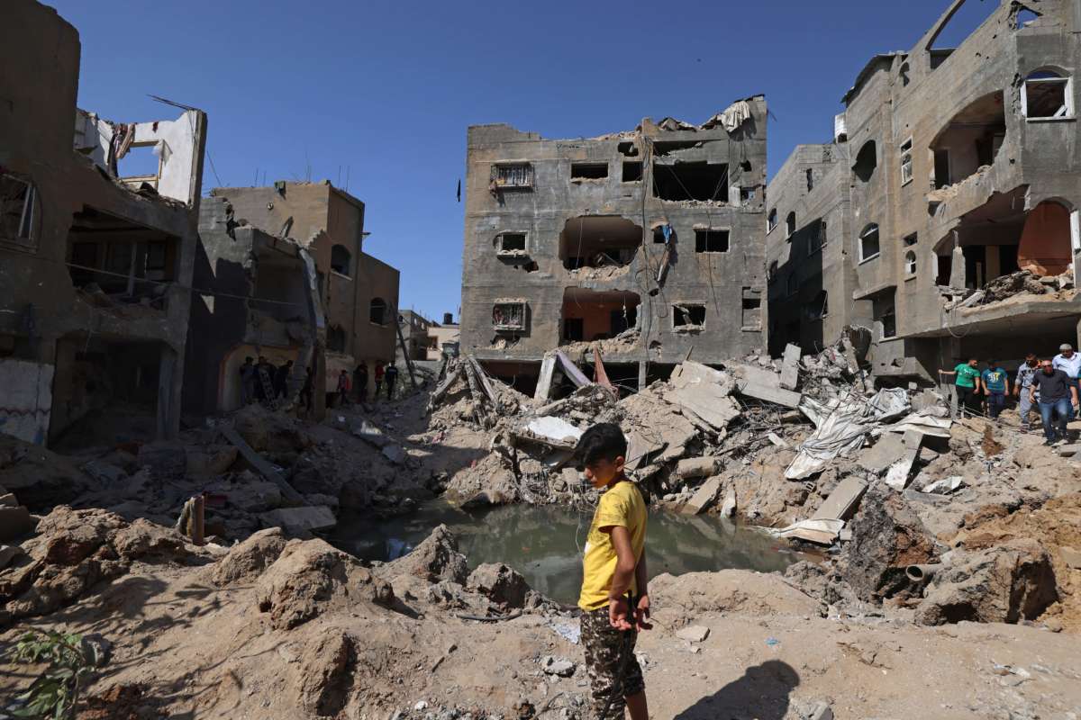 A Palestinian child stands amid the rubble of buildings, destroyed by Israeli strikes, in Beit Hanun in the northern Gaza Strip on May 21, 2021.