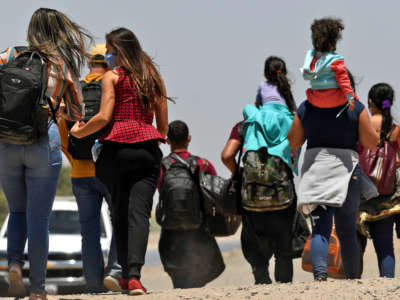 Migrants attempting to cross in to the U.S. from Mexico are detained by U.S. Customs and Border Protection at the border on May 21, 2021, in San Luis, Arizona.